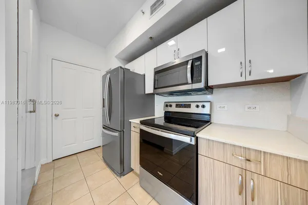 a kitchen with stainless steel appliances granite countertop a refrigerator microwave and sink