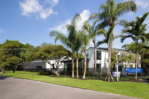 a front view of a house with garden and trees