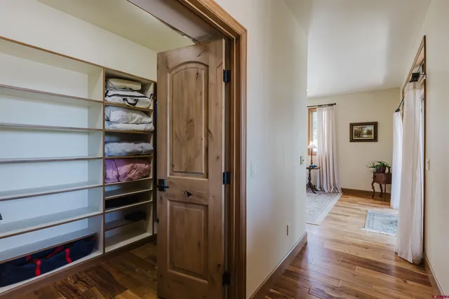 a view of a hallway with wooden floor and closet