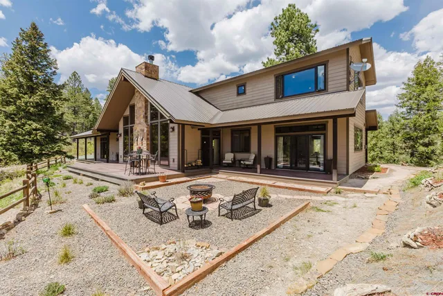 a view of a house with backyard and sitting area