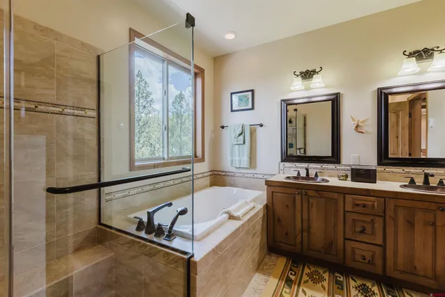 a bathroom with a tub sink and mirror