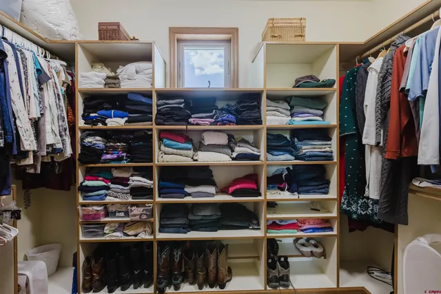a view of walk in closet with clothes and shoes