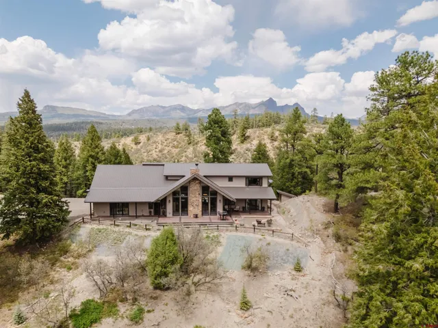 an aerial view of a house with a garden and trees