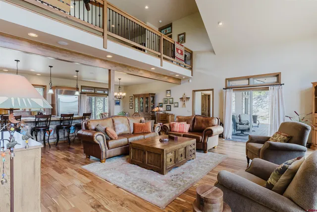 a living room with furniture kitchen view and a large window