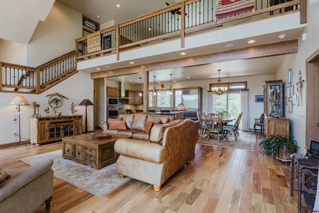 a living room with furniture a fireplace and potted plants with wooden floor