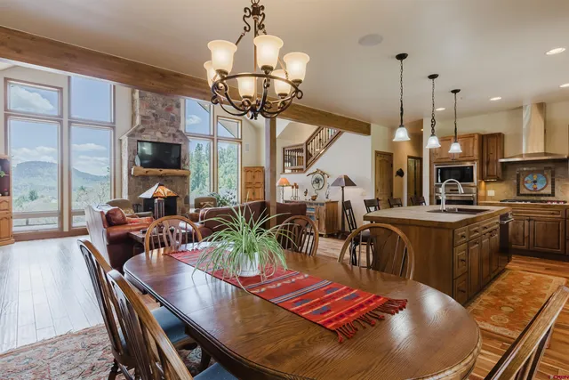 a dining room with furniture a chandelier and wooden floor