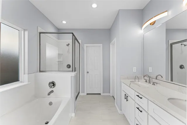 a spacious bathroom with a tub shower and mirror
