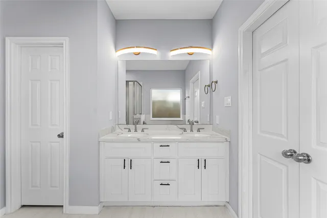 a spacious bathroom with a double vanity sink and a mirror