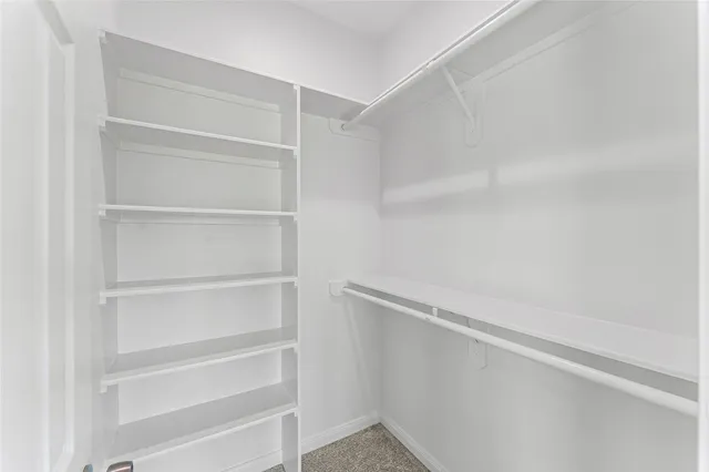 a view of walk in closet with empty racks