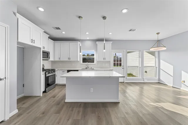 a large kitchen with stainless steel appliances and a large counter top