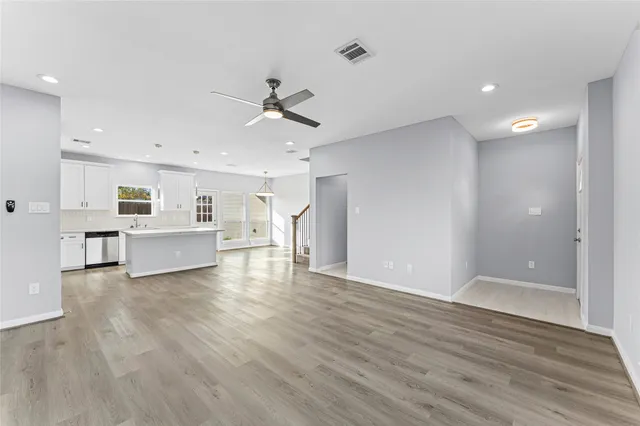 a view of a livingroom with a ceiling fan wooden floor and window