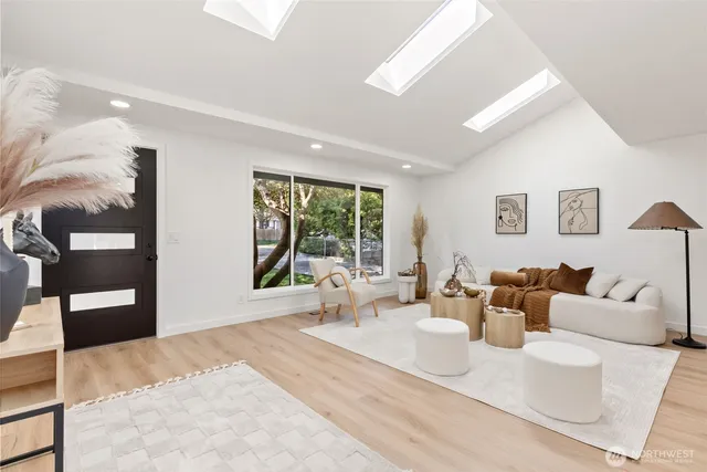a living room with furniture a wooden floor and kitchen view