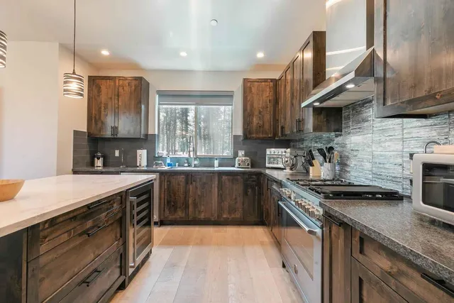 a kitchen with a sink a stove top oven and wooden floor