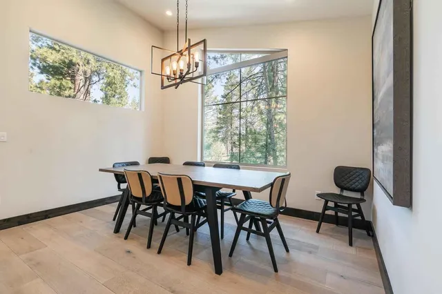 a view of a dining room with furniture a chandelier and wooden floor