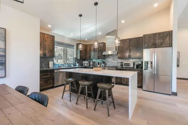 a kitchen with kitchen island a refrigerator a stove a sink and a chairs