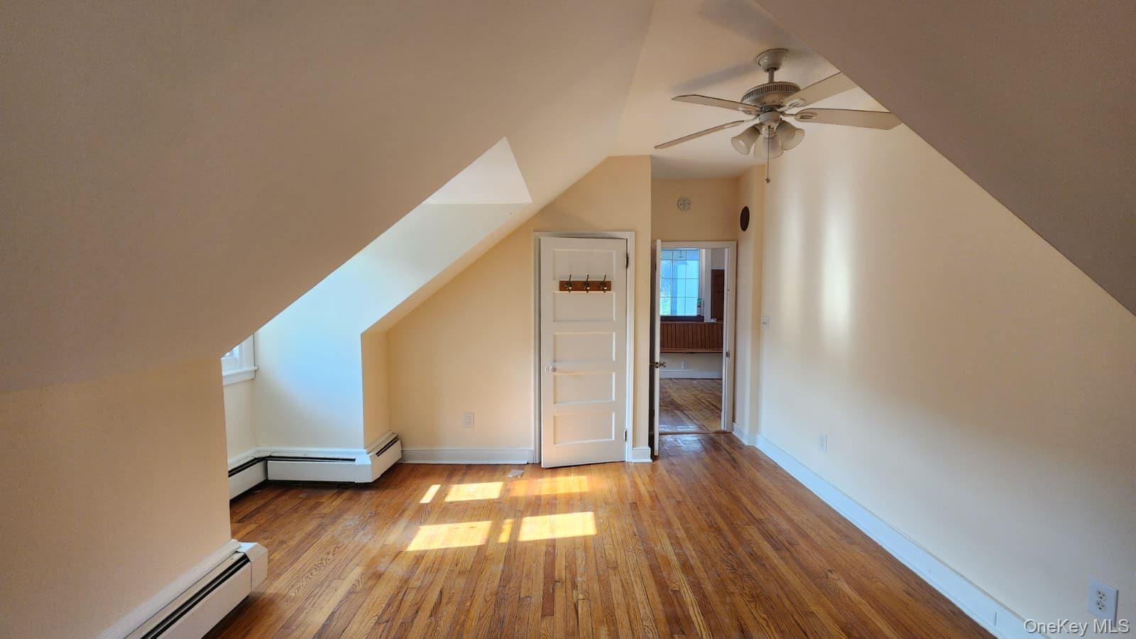 92 Roe Avenue, Unit 3 Highland Falls, NY 10928 - Photo 11 of 17 Spacious room featuring wood-finish flooring, a ceiling fan, and sloped high ceilings