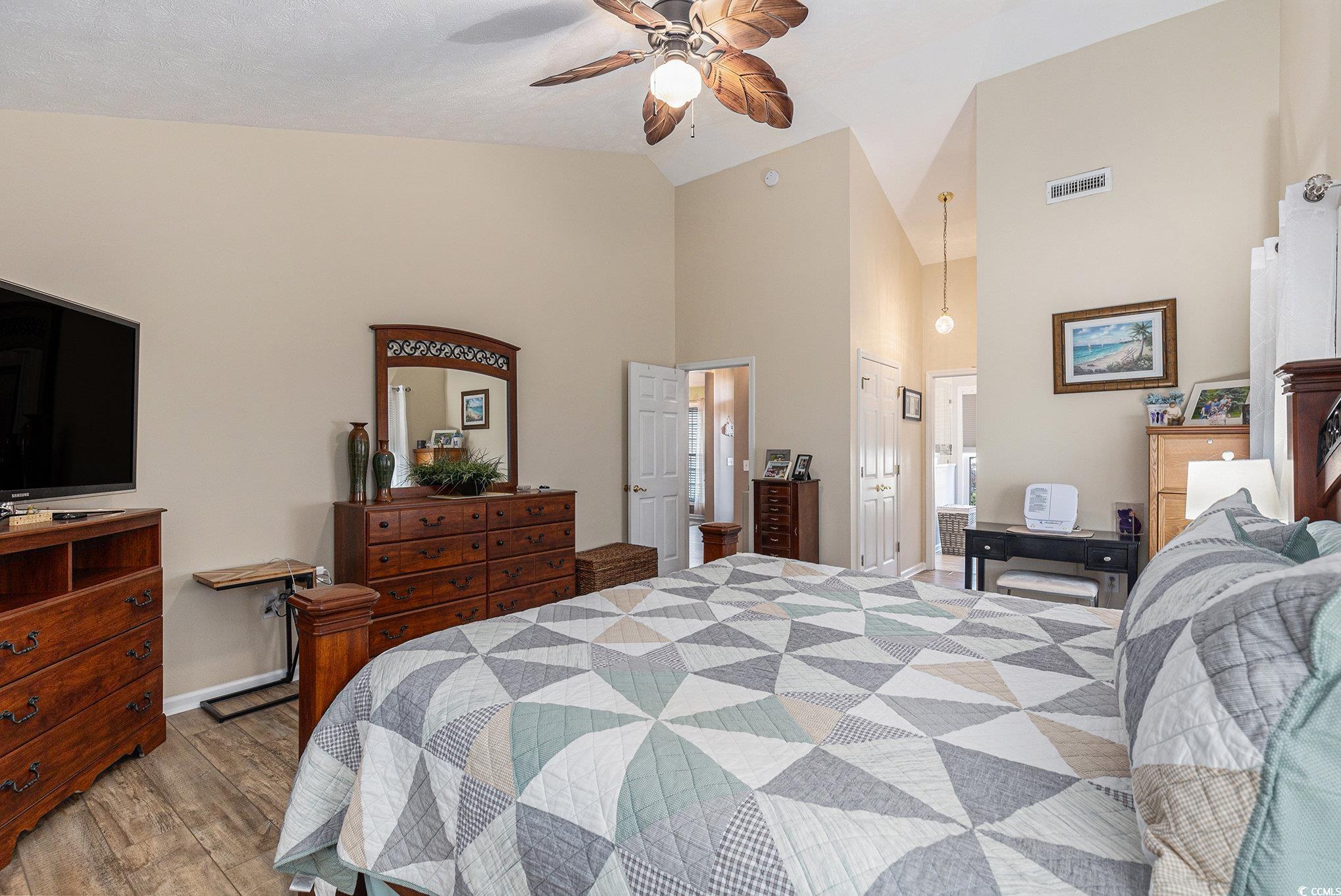 1105 Lampwick Lane Murrells Inlet, SC 29576 - Photo 21 of 40 Bedroom featuring wood finished floors, high vaulted ceiling, baseboards, connected bathroom, and ceiling fan
