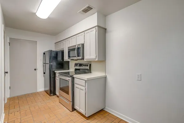 a kitchen with stainless steel appliances a stove microwave and refrigerator