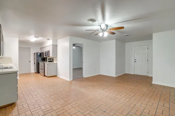 a view of an empty room with window and cabinet