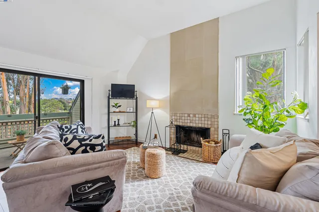 a living room with furniture fireplace and a large window