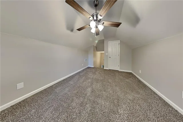 an empty room with a chandelier fan and a ceiling fan