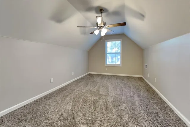 an empty room with a window and a chandelier fan
