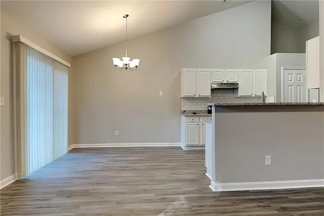 a view of a kitchen with stainless steel appliances wooden floor and chair