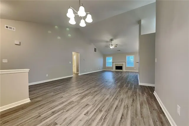 a view of a room with wooden floor and a ceiling fan