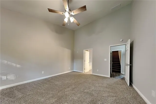 an empty room with a ceiling fan and window