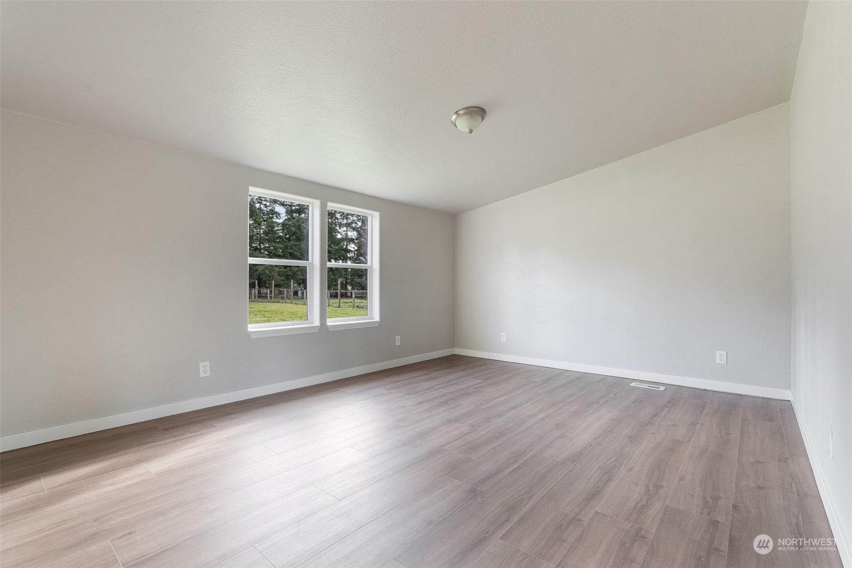 18740 Ivan Street Southwest Rochester, WA 98579 - Photo 13 of 39 a view of an empty room with wooden floor and a window