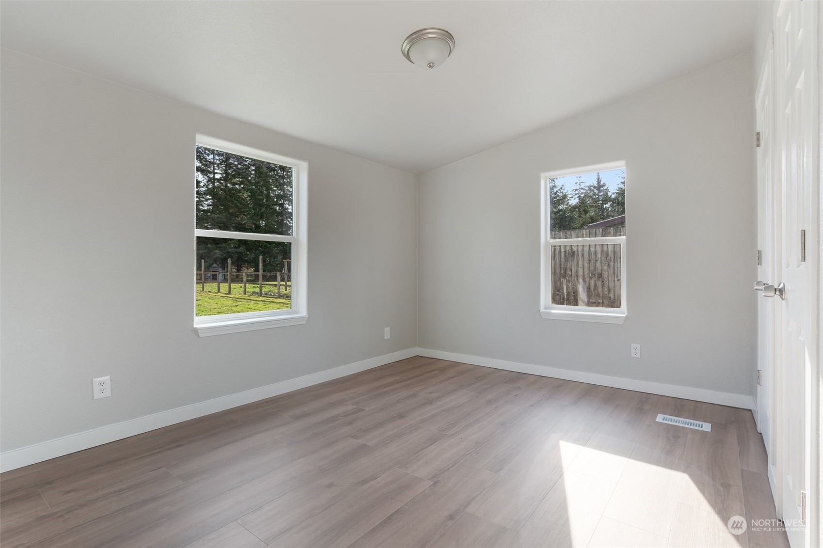 18740 Ivan Street Southwest Rochester, WA 98579 - Photo 21 of 39 a view of an empty room with a window and wooden floor