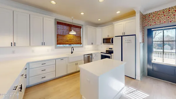 a kitchen with white cabinets and stainless steel appliances