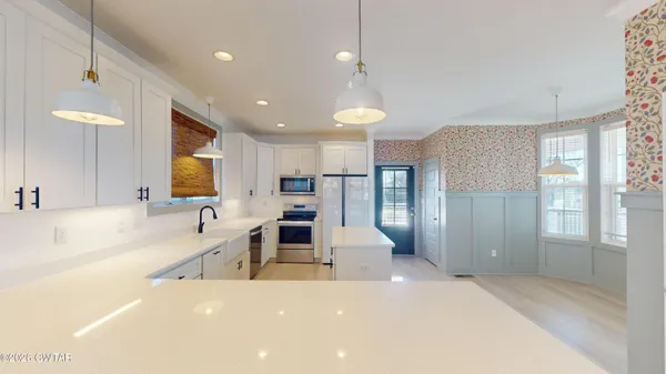 a large kitchen with a large window a sink and stainless steel appliances