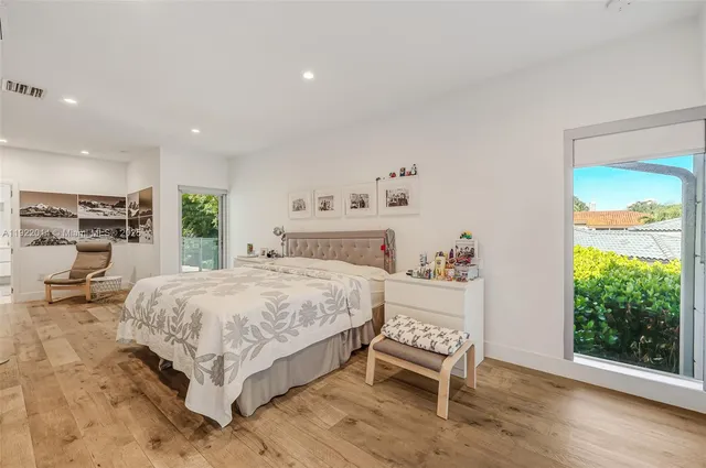 a bedroom with a bed a chair and a large window