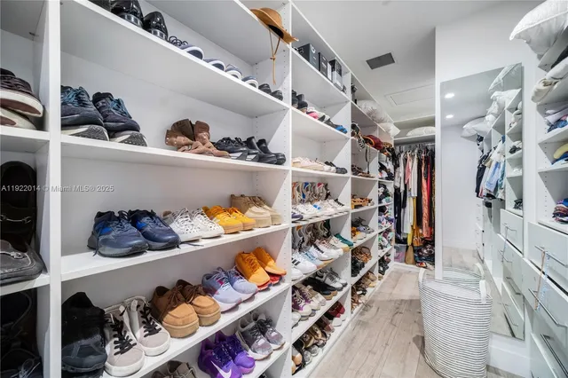 a view of walk in closet with clothes and shoes