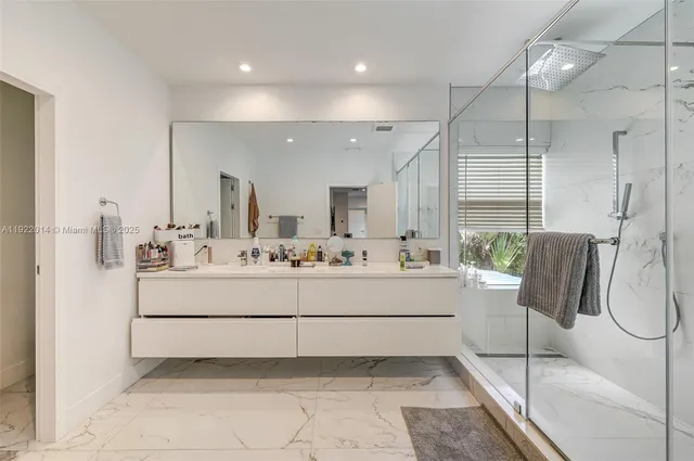 a bathroom with a sink a mirror and a shower