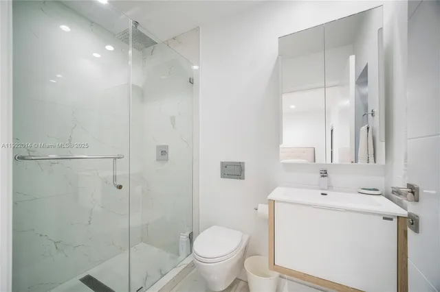 a bathroom with a granite countertop sink toilet and shower