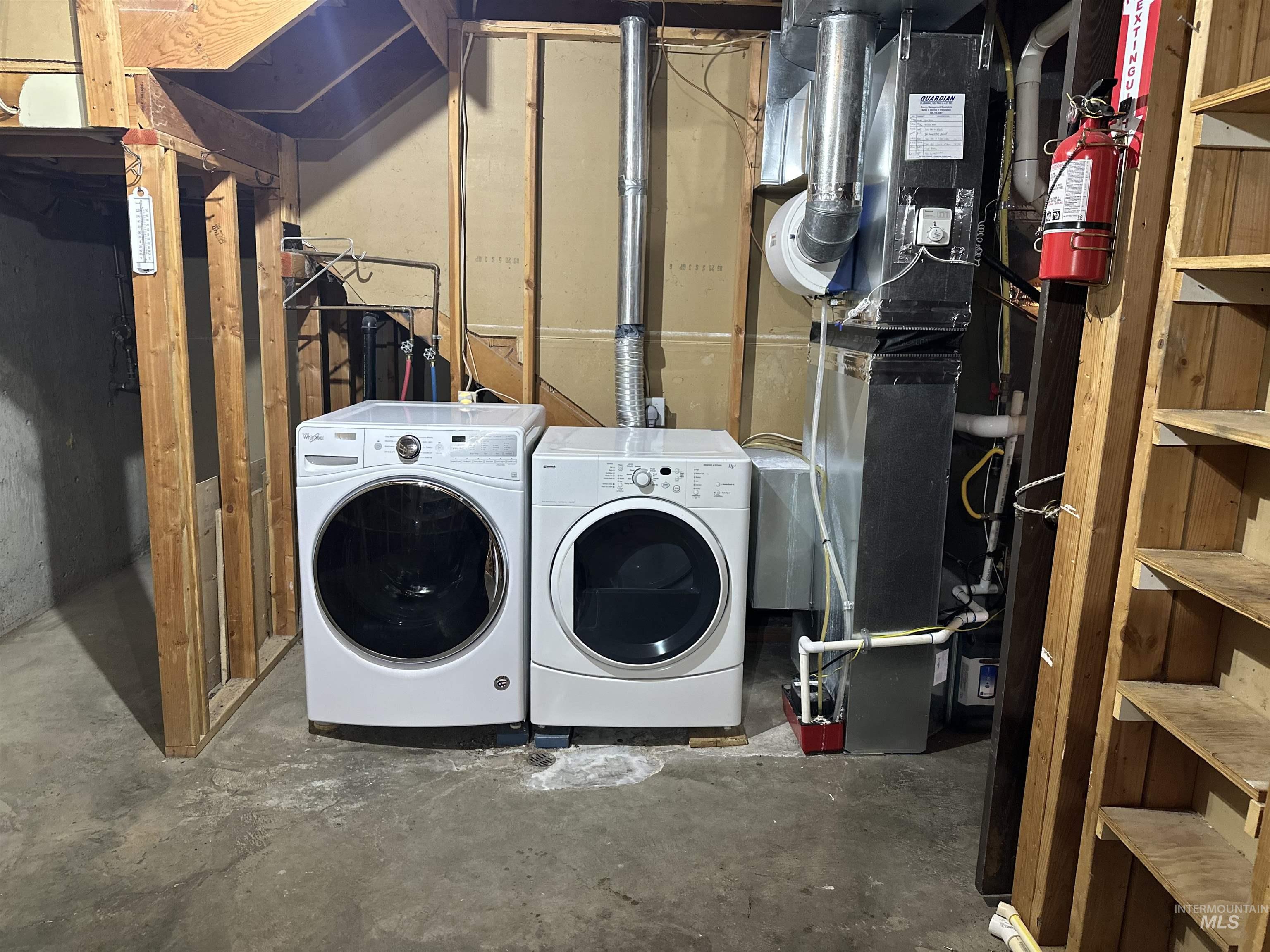1620 6th Avenue Clarkston, WA 99403 - Photo 17 of 19 Dedicated laundry area featuring a white front-loading washer and dryer set, adjacent to a utility furnace