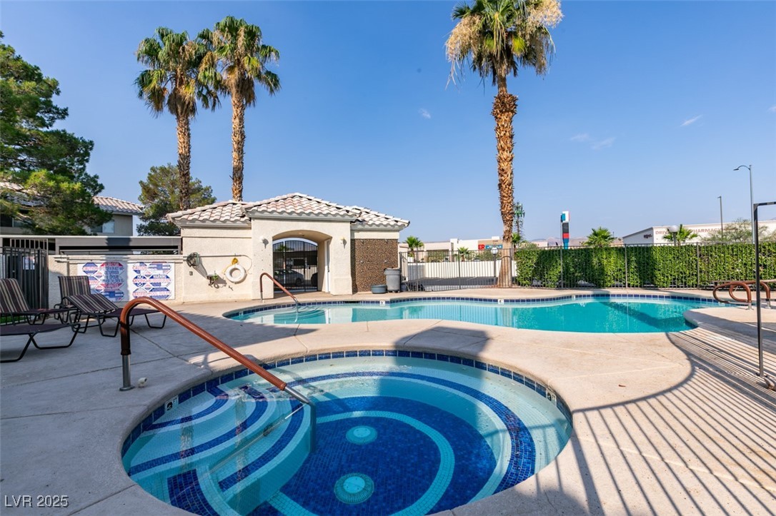 Community pool with a hot tub and a patio area