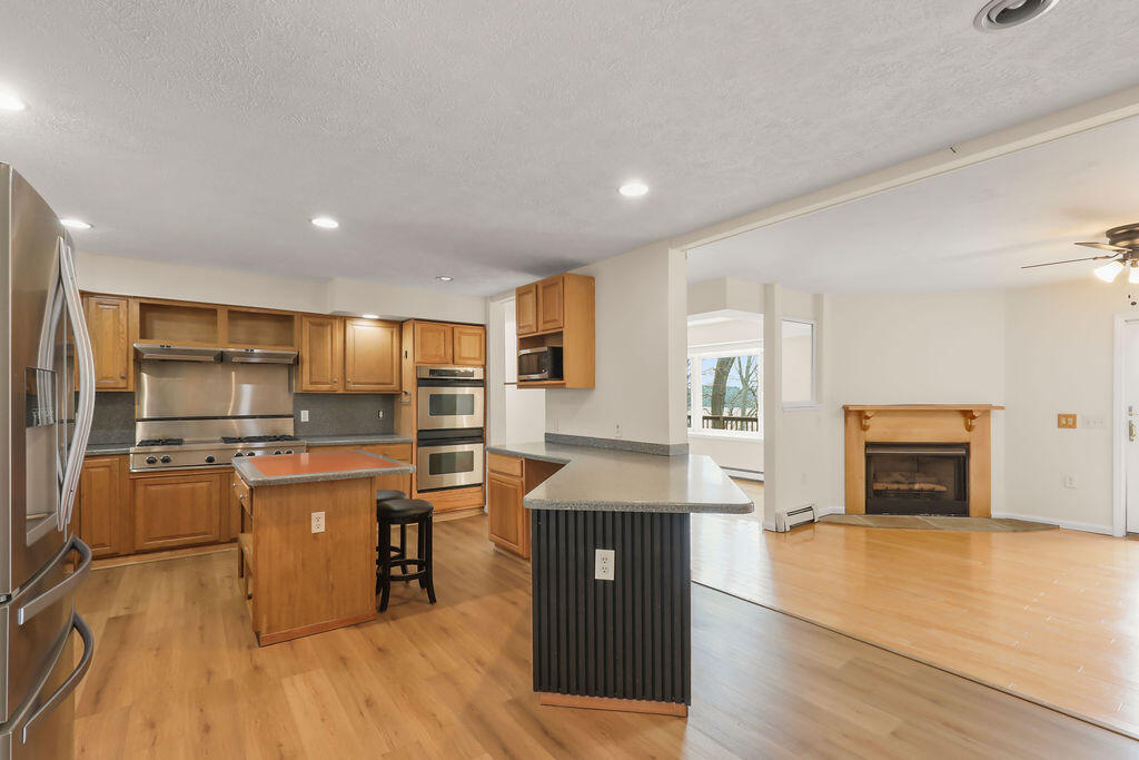 75 Edgewater Road Mashpee, MA 02649 - Photo 9 of 78 a kitchen with stainless steel appliances granite countertop a stove top oven a sink dishwasher and a refrigerator with wooden floor