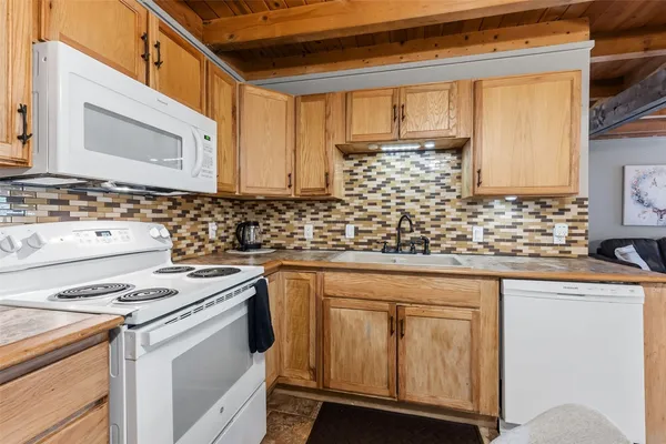 a kitchen with cabinets appliances a sink and a counter top space