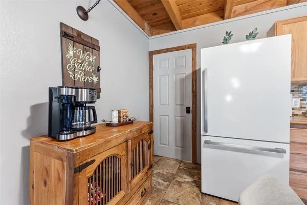 a view of a kitchen with fridge and wooden floor