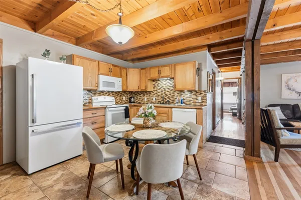 a dining room with furniture a kitchen view and a refrigerator
