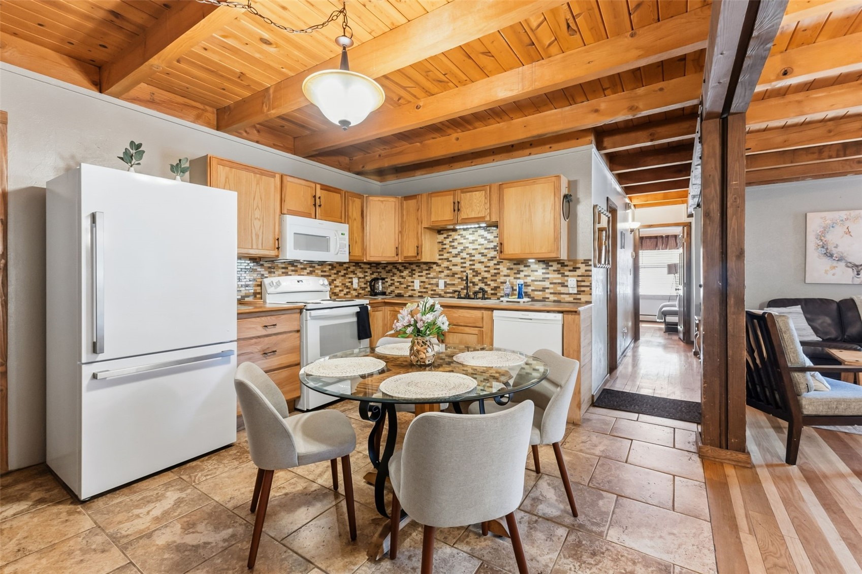 8500 Ryan Gulch Road, Unit 206 Silverthorne, CO 80498 - Photo 9 of 34 a dining room with furniture a kitchen view and a refrigerator