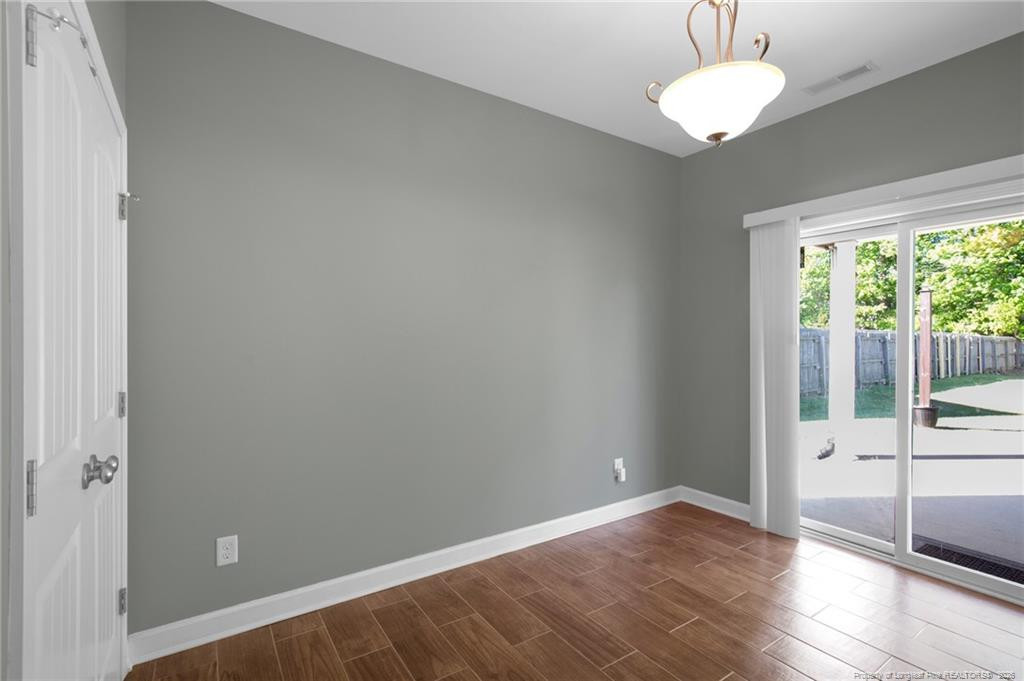 132 Shellbark Drive Spring Lake, NC 28390 - Photo 16 of 44 a view of an empty room with wooden floor and a window