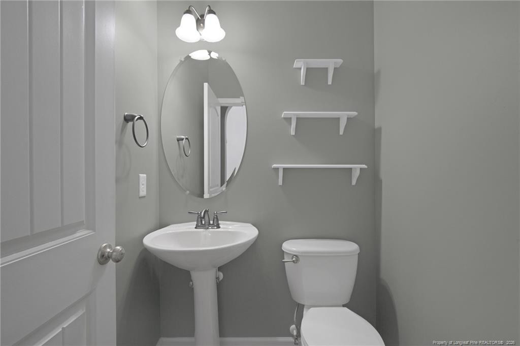 132 Shellbark Drive Spring Lake, NC 28390 - Photo 17 of 44 a bathroom with a toilet a sink and mirror