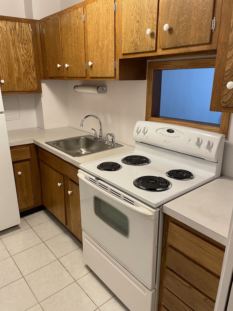 5601 North Sheridan Road, Unit 6D Chicago, IL 60660 - Photo 5 of 11 a kitchen with a stove cabinets and utility