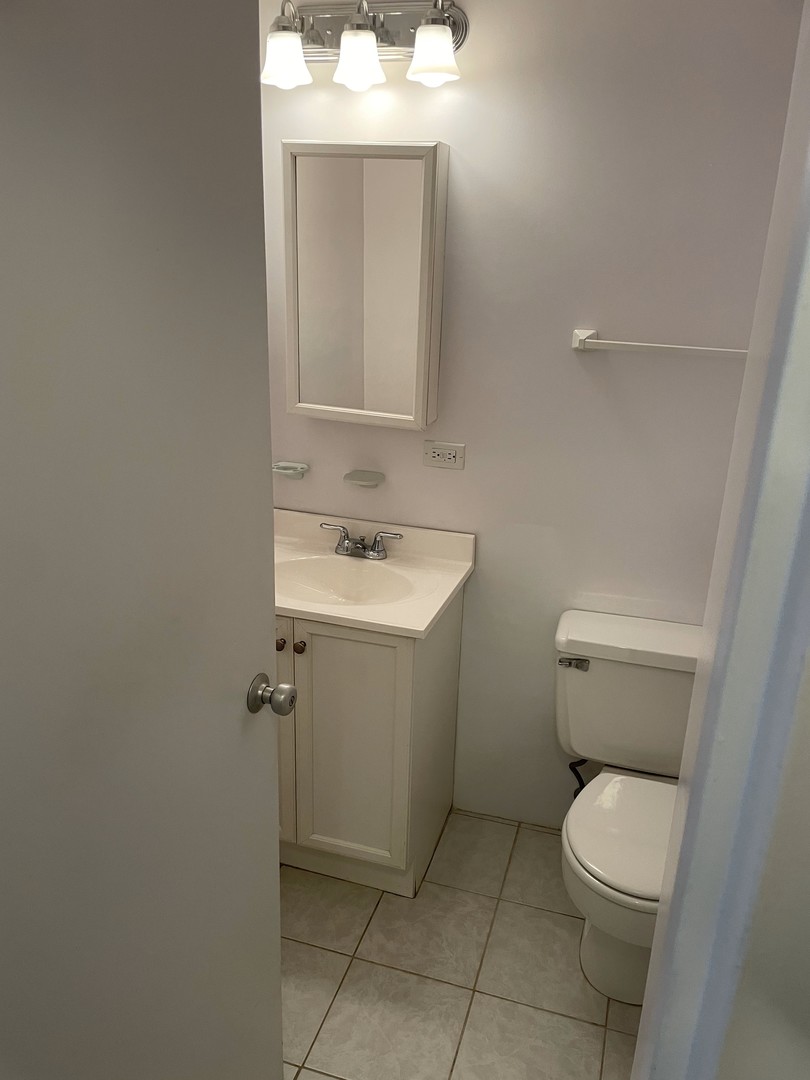5601 North Sheridan Road, Unit 6D Chicago, IL 60660 - Photo 9 of 11 a bathroom with a toilet sink and mirror