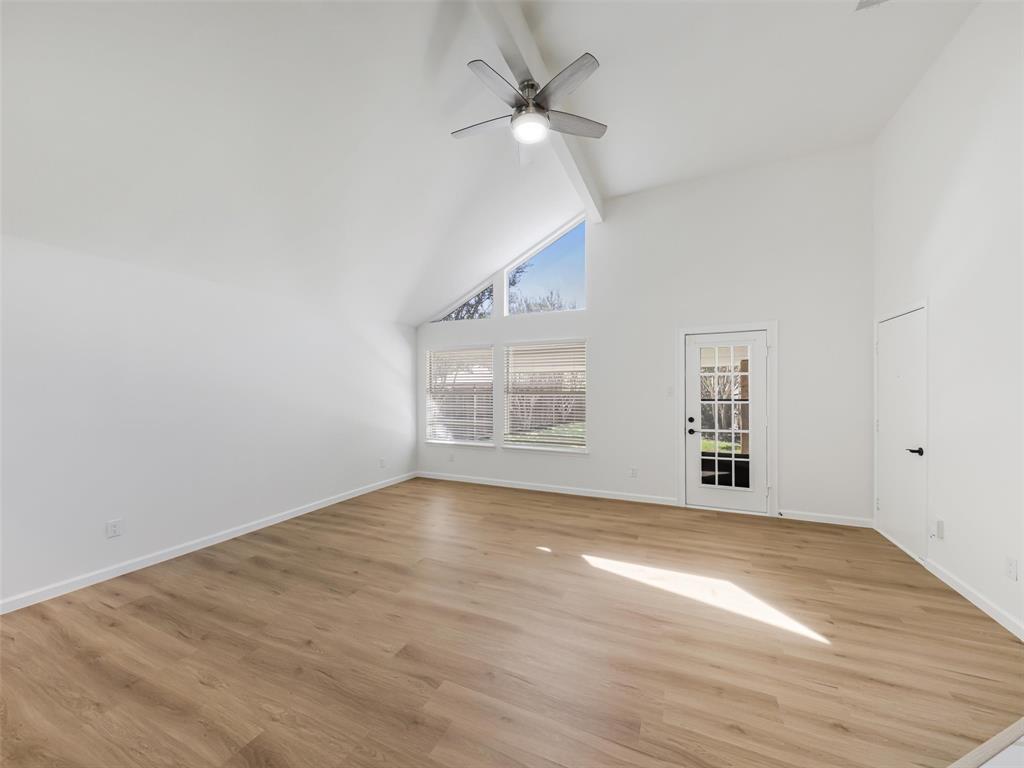 Vaulted ceiling, ceiling fan, wood-finish flooring, French door, and large windows