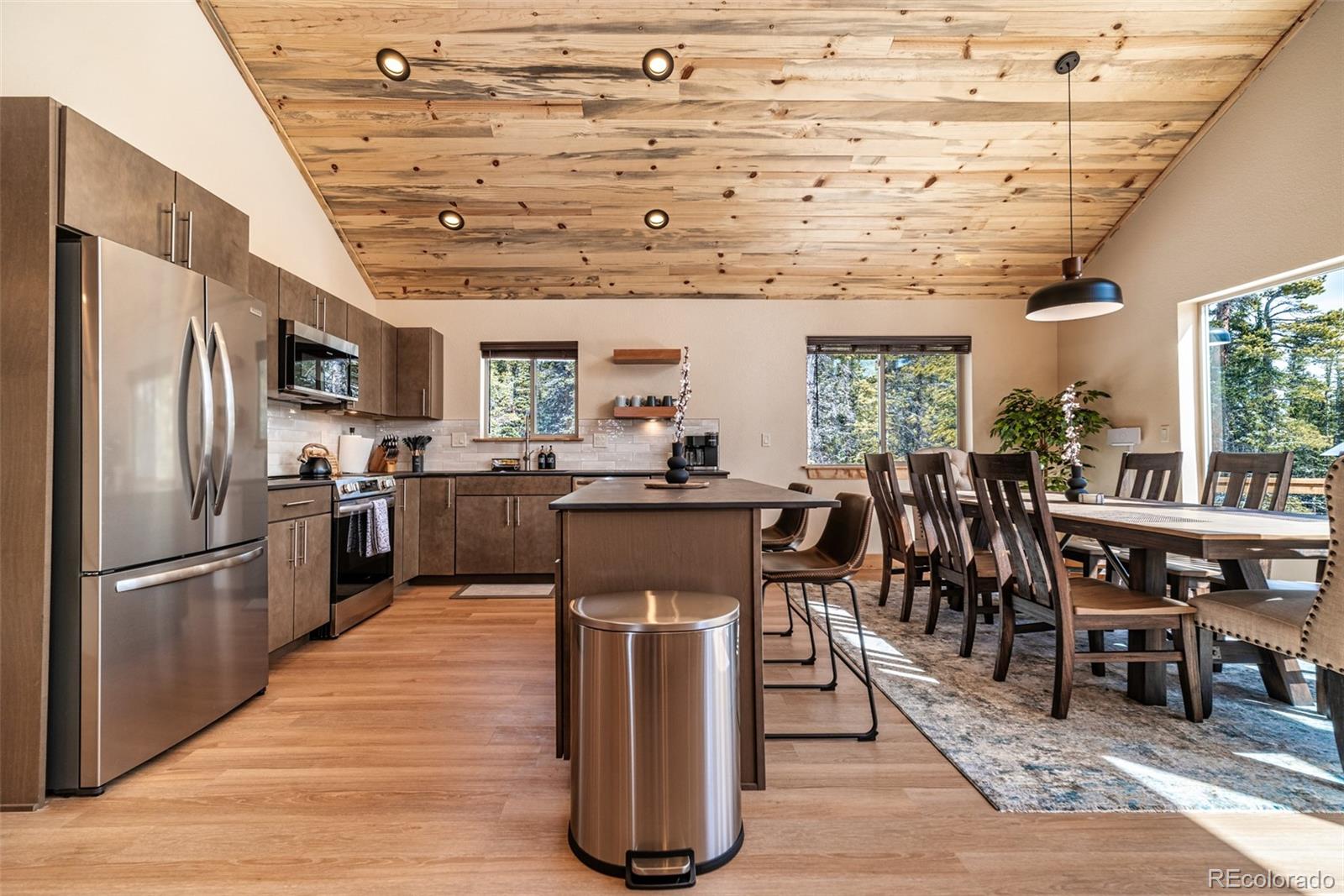 526 Porcupine Road Fairplay, CO 80440 - Photo 3 of 46 a kitchen with stainless steel appliances granite countertop a refrigerator a stove top oven a dining table and chairs with wooden floor